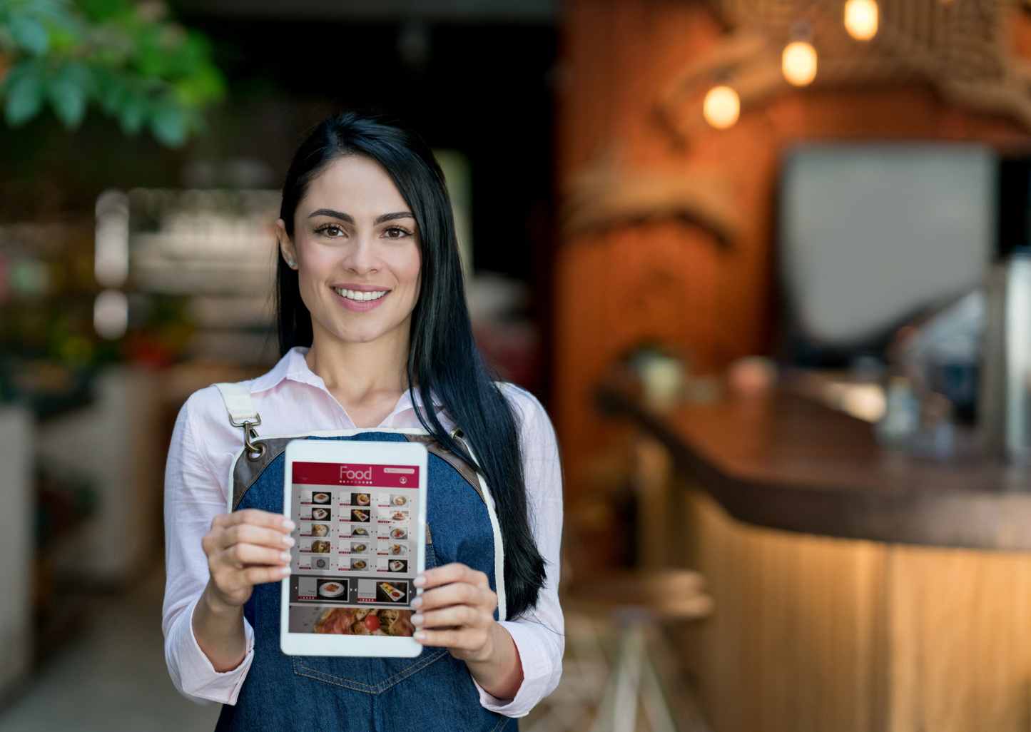 Waitress holding a tablet computer with the menu at a restaurant